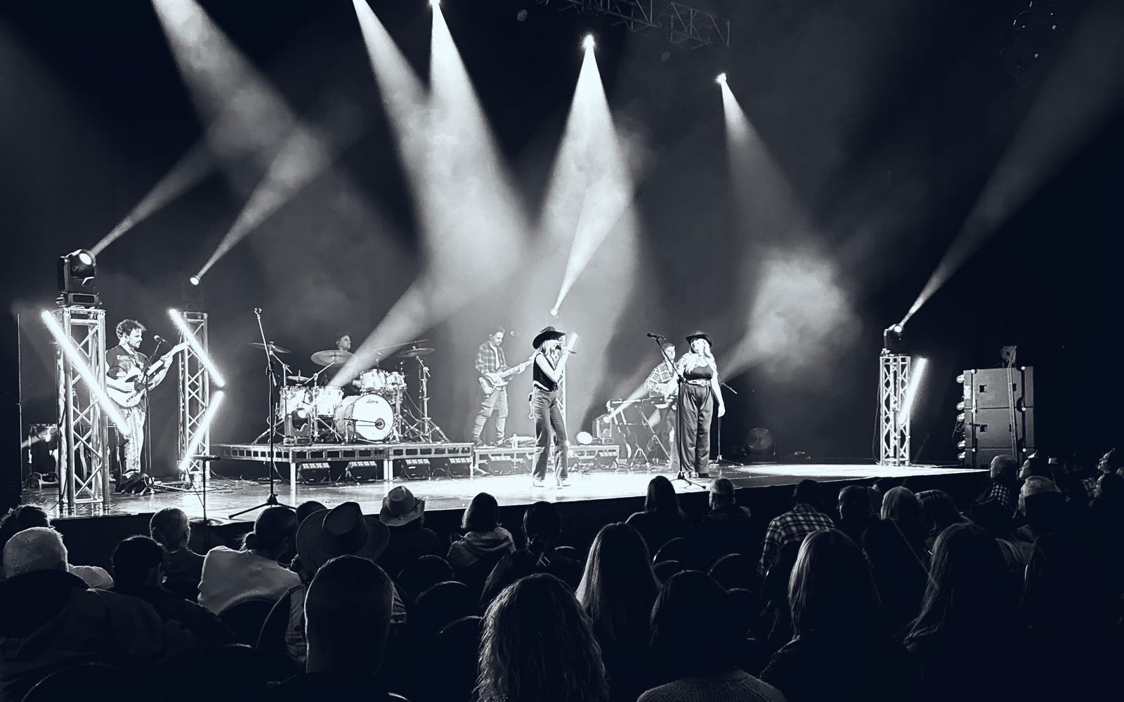 A wide view of the Nashville At Heart stage under beams of light