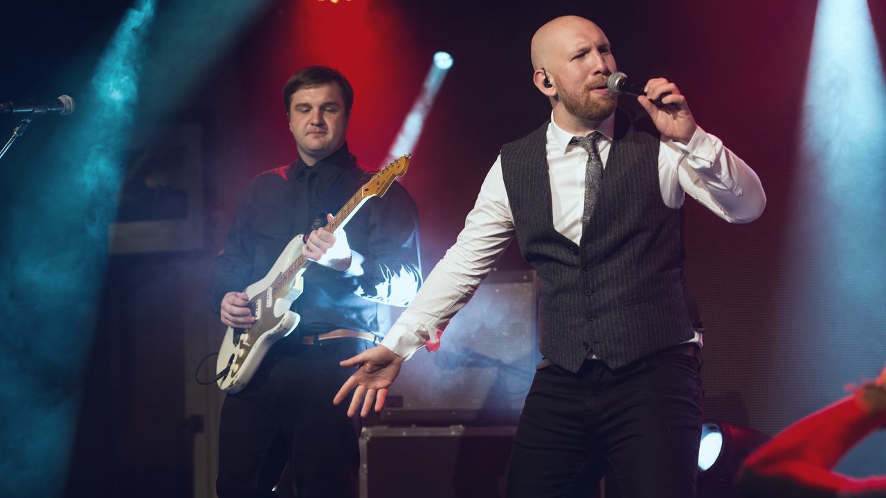 Captain Atlantic's singer on stage under coloured light